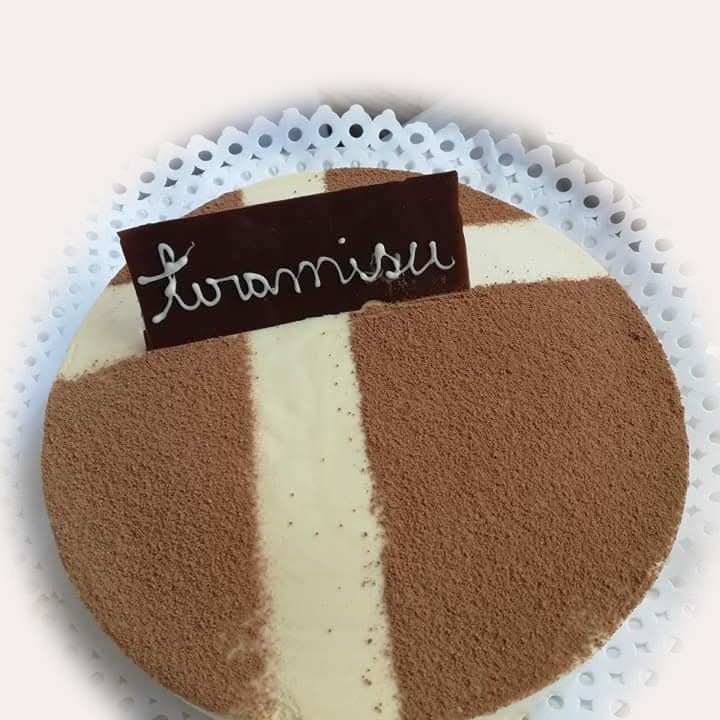 Tiramisú con cacao y letrero de chocolate.